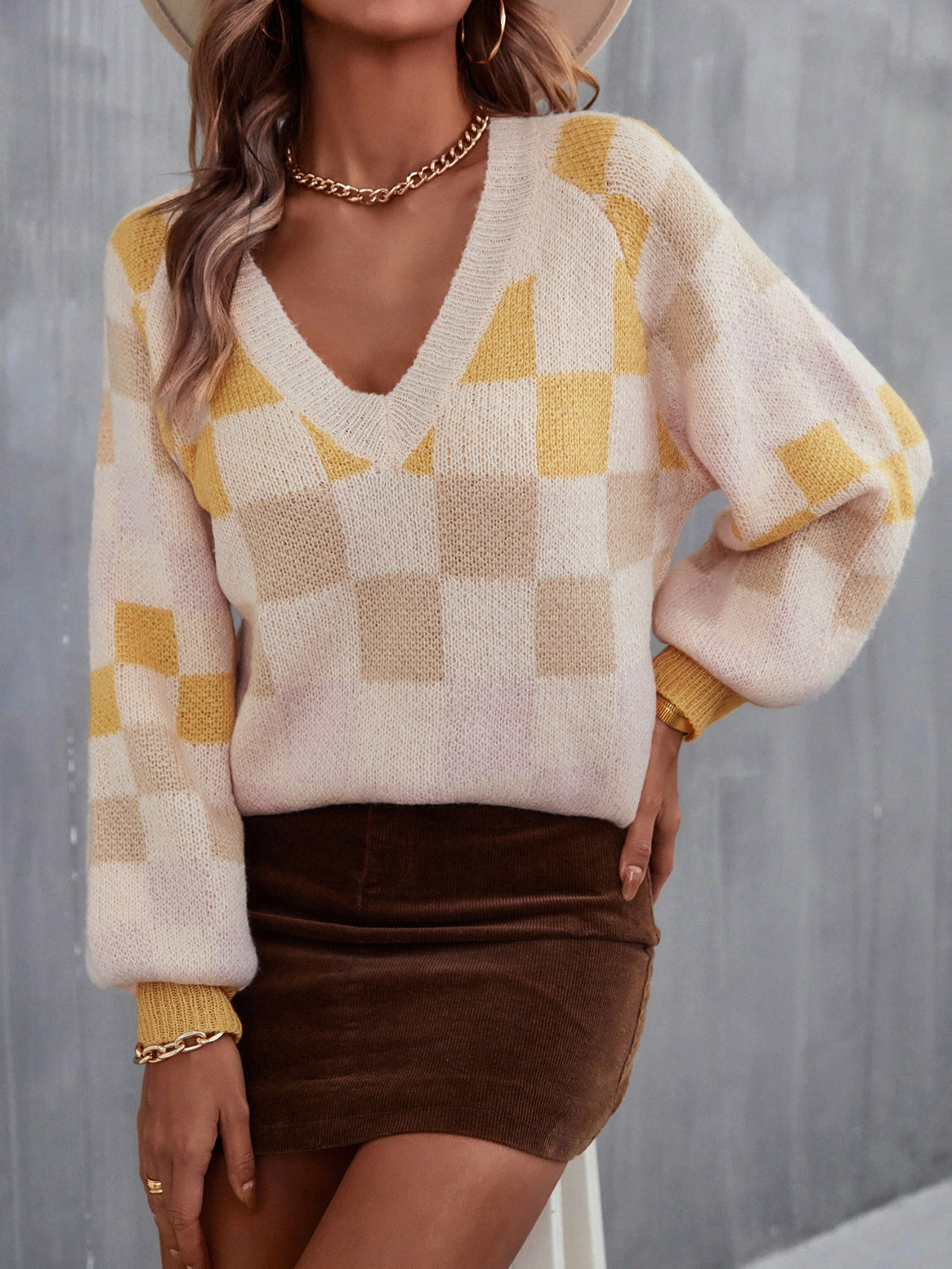 Trendy checkered v-neck sweater with lantern sleeves, perfect for a cozy and stylish look.