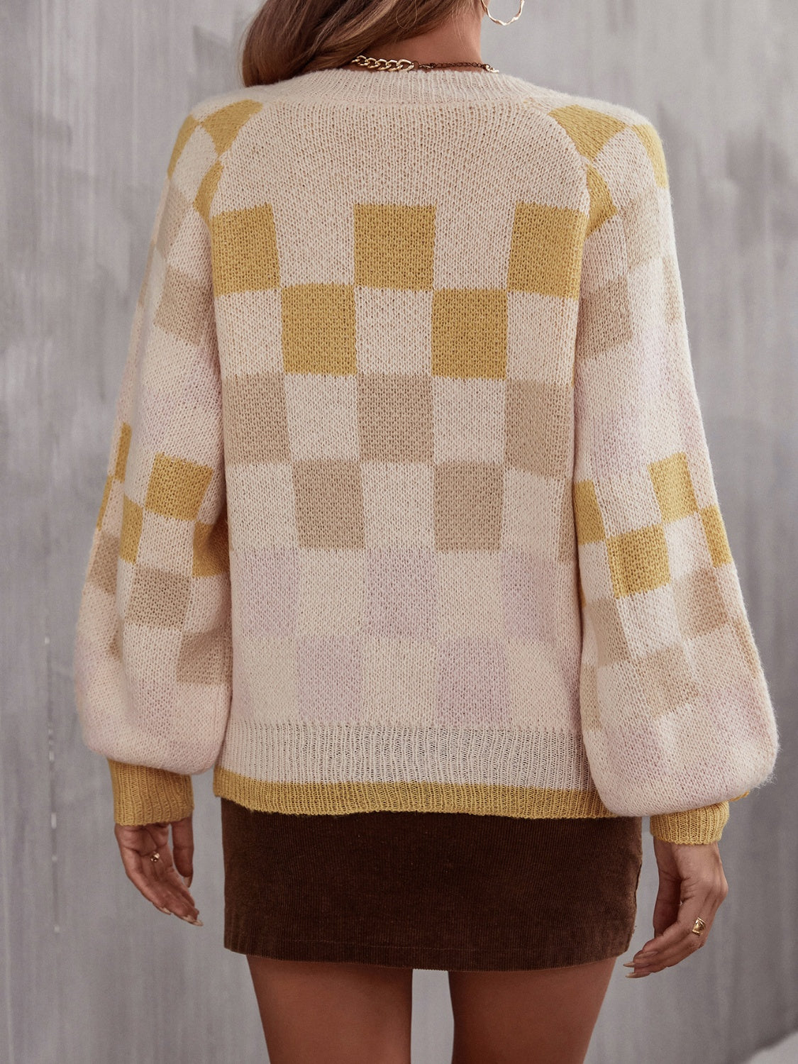 Trendy checkered v-neck sweater with lantern sleeves, perfect for a cozy and stylish look.