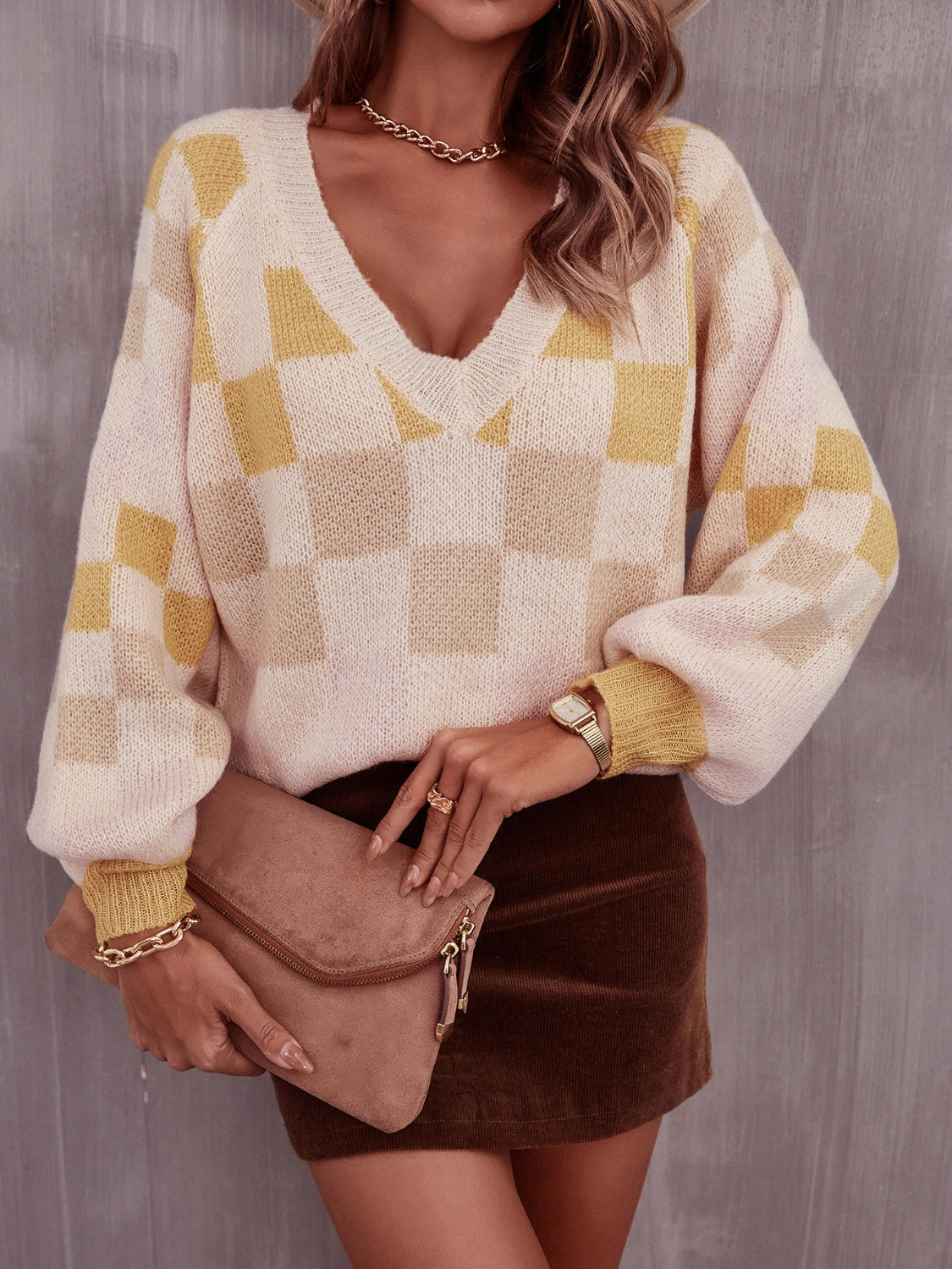 Trendy checkered v-neck sweater with lantern sleeves, perfect for a cozy and stylish look.